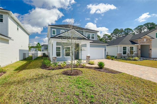 view of front of house with a garage, decorative driveway, a front yard, and fence