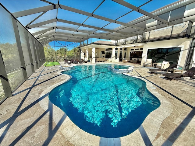 view of pool featuring a lanai, a pool with connected hot tub, and a patio