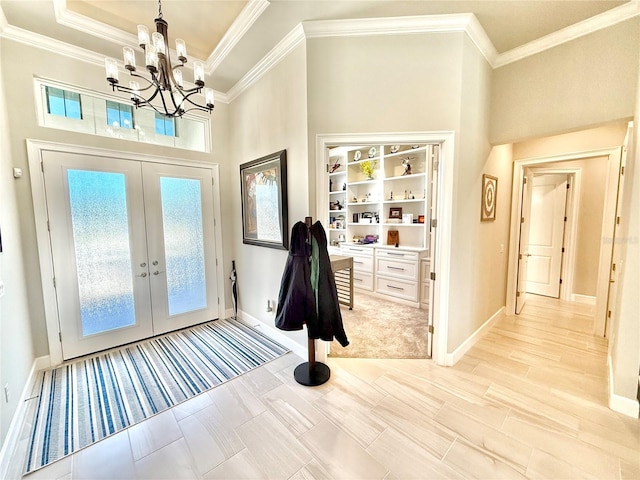 entrance foyer featuring a raised ceiling, french doors, a high ceiling, crown molding, and baseboards