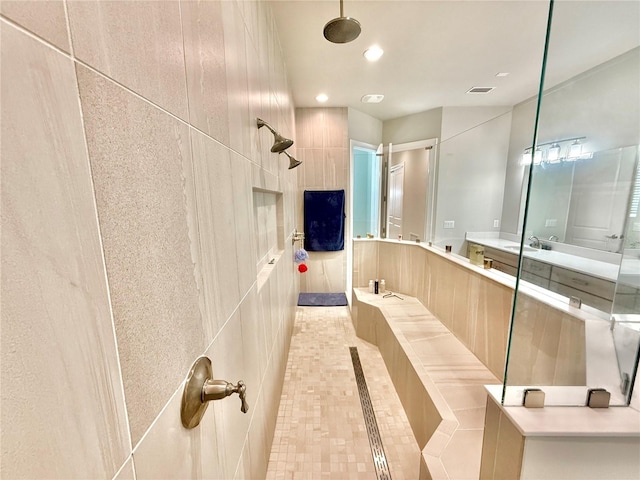 bathroom featuring tile patterned floors, visible vents, a tile shower, recessed lighting, and vanity