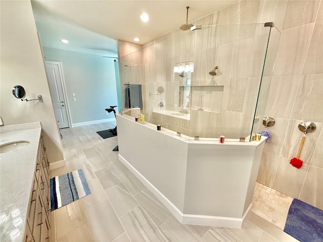 bathroom with vanity, baseboards, recessed lighting, tile patterned flooring, and walk in shower