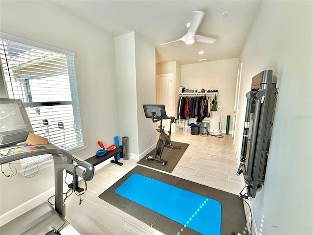 exercise room with baseboards and ceiling fan