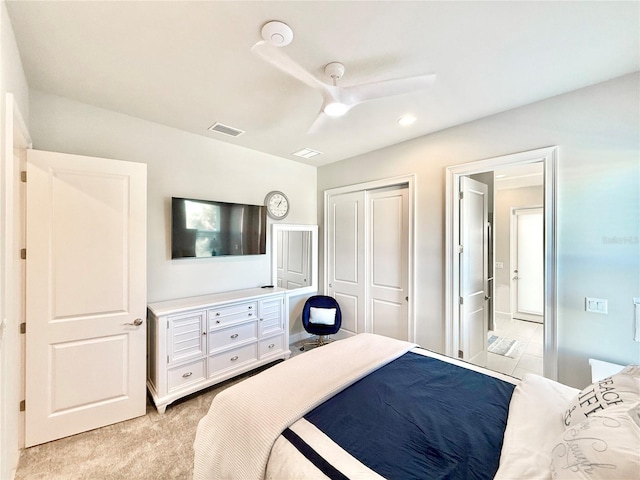 bedroom with visible vents, light carpet, a closet, and a ceiling fan