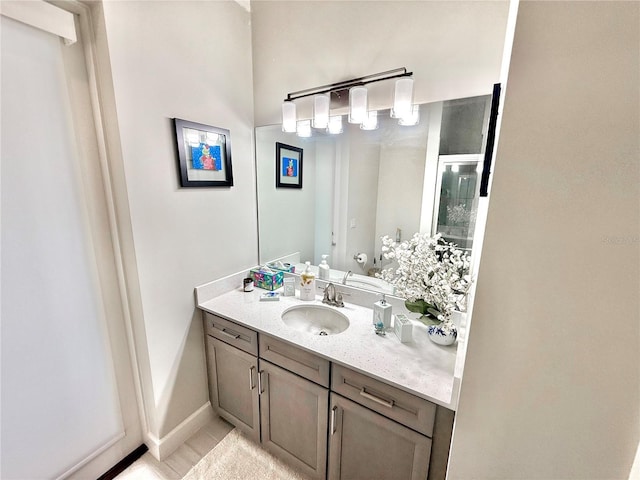 bathroom with toilet, vanity, and baseboards