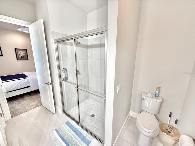 ensuite bathroom with toilet, a stall shower, ensuite bathroom, tile patterned flooring, and baseboards