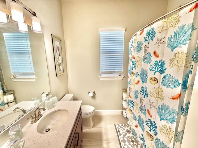 bathroom featuring tile patterned floors, toilet, a shower with shower curtain, baseboards, and vanity