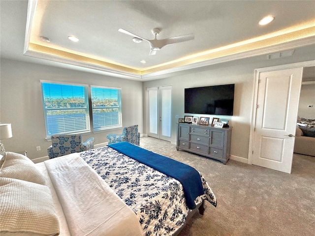 bedroom featuring a tray ceiling, baseboards, and carpet flooring