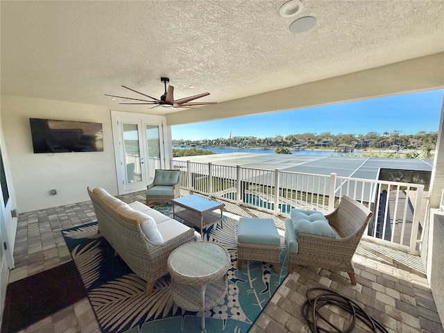 view of patio featuring a balcony, french doors, a water view, and ceiling fan