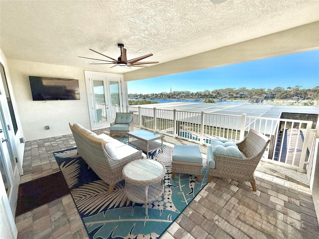 view of patio / terrace with a ceiling fan, a balcony, and french doors