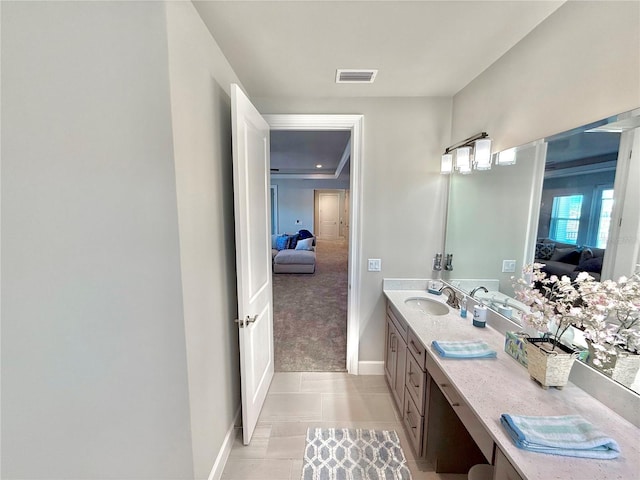 bathroom with visible vents, vanity, ensuite bathroom, and baseboards