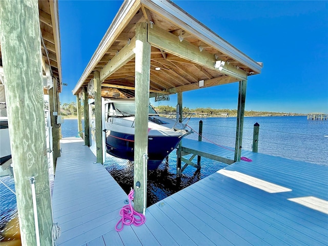 dock area with boat lift and a water view