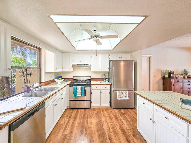 83 Farragut Dr, Palm Coast, FL 32137 - kitchen with stainless steel appliances, tile countertops, under cabinet range hood, and ceiling fan