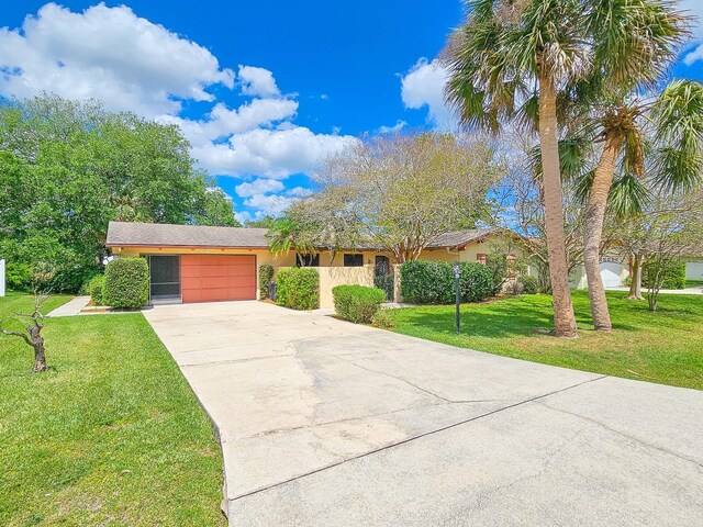 83 Farragut Dr, Palm Coast, FL 32137 - view of front facade featuring an attached garage, driveway, a front lawn, and stucco siding