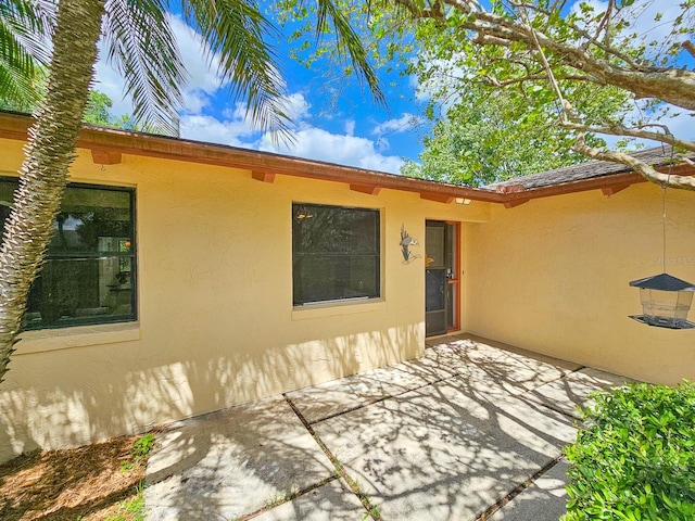 83 Farragut Dr, Palm Coast, FL 32137 - view of exterior entry with stucco siding and a patio area