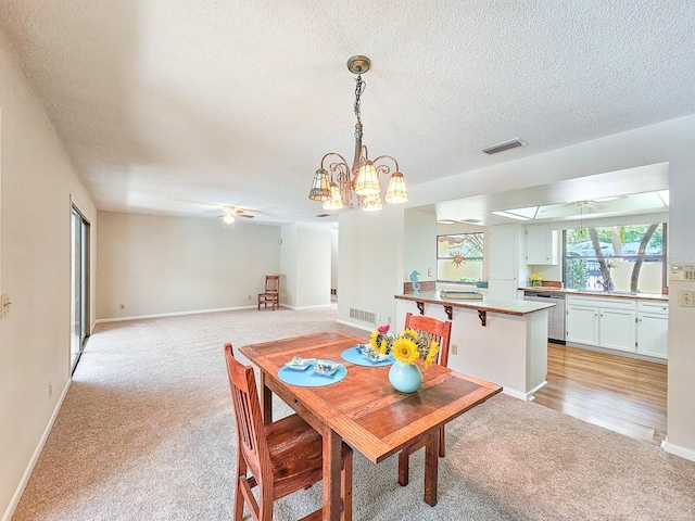 83 Farragut Dr, Palm Coast, FL 32137 - dining area with light carpet, ceiling fan, a chandelier, and a textured ceiling