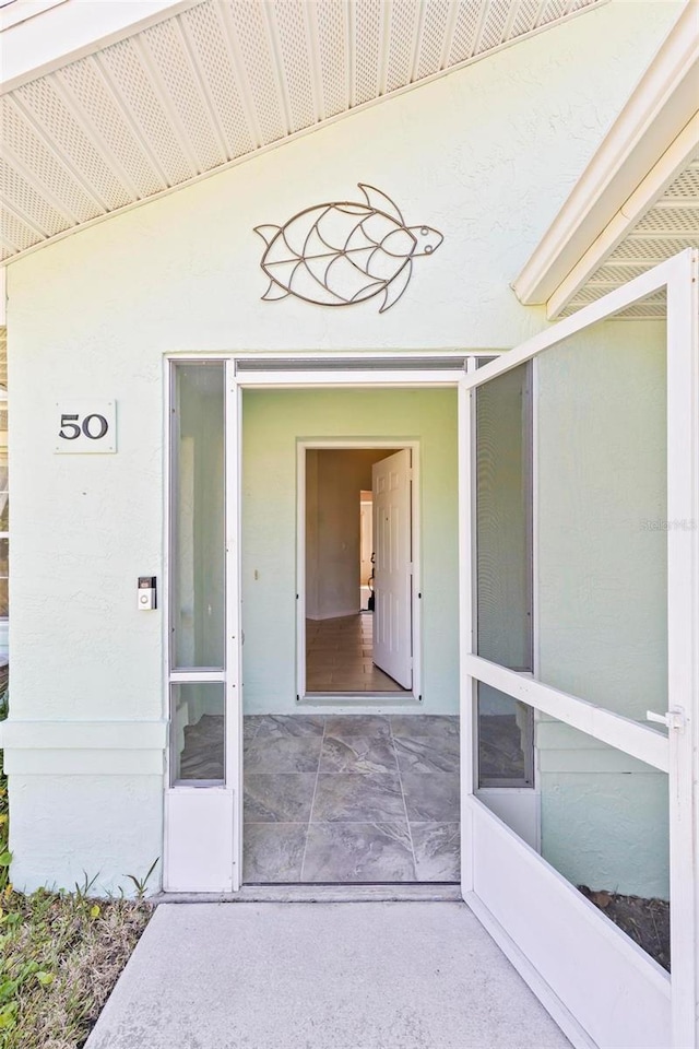 view of exterior entry with stucco siding