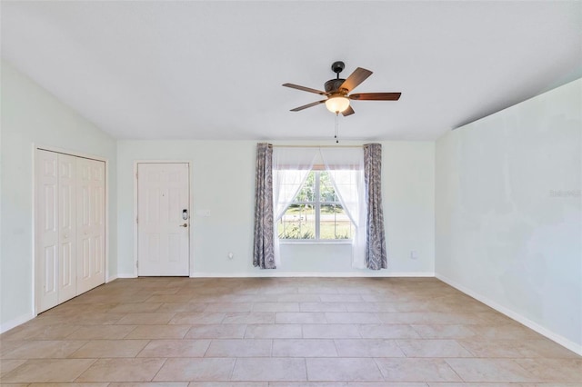 spare room with baseboards, lofted ceiling, and a ceiling fan