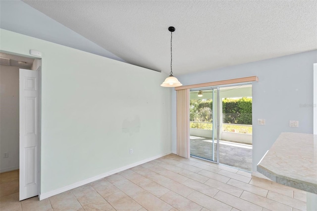 unfurnished dining area featuring lofted ceiling, light tile patterned floors, baseboards, and a textured ceiling