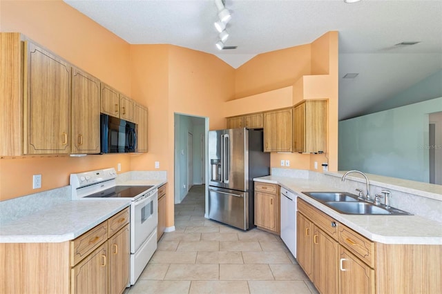 kitchen with a sink, white appliances, a peninsula, and light countertops