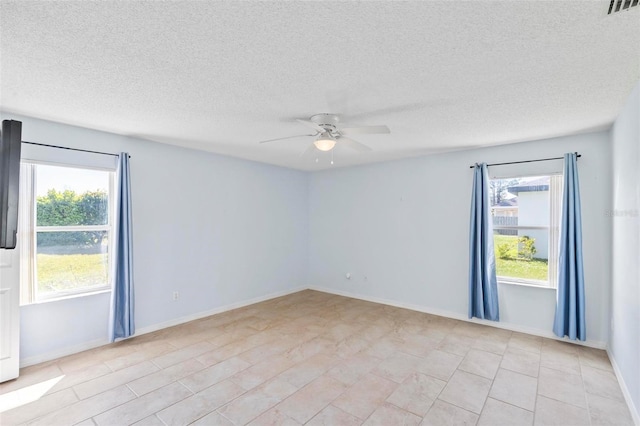 empty room with visible vents, baseboards, a healthy amount of sunlight, and a ceiling fan