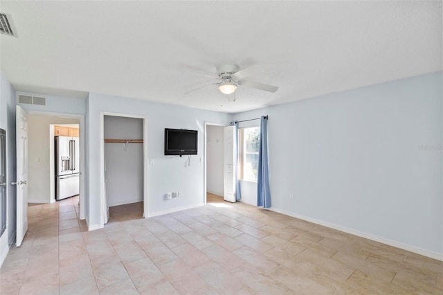 unfurnished bedroom featuring baseboards, visible vents, a closet, and high end refrigerator