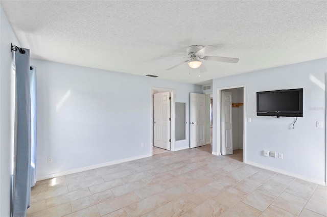 interior space with visible vents, a textured ceiling, baseboards, and a ceiling fan