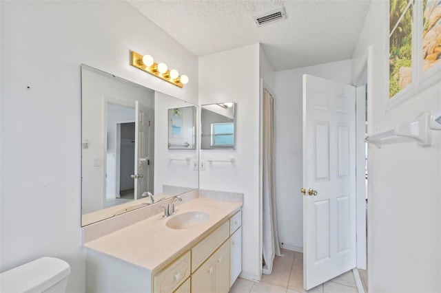 full bathroom featuring vanity, visible vents, tile patterned flooring, a textured ceiling, and toilet