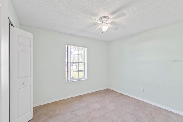 spare room with a ceiling fan, baseboards, and a textured ceiling