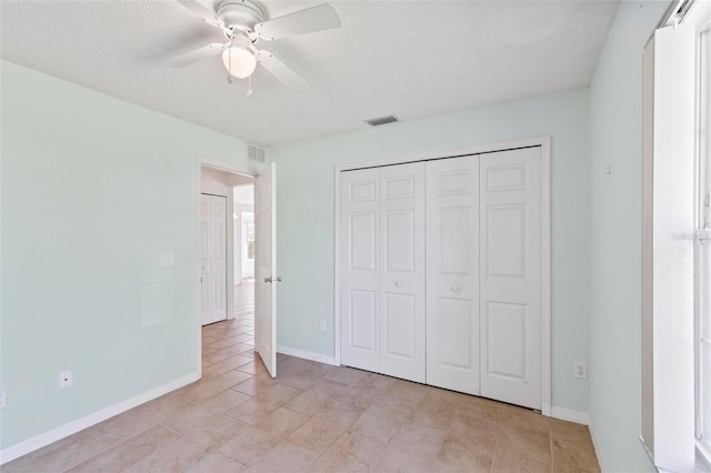 unfurnished bedroom featuring a closet, visible vents, a textured ceiling, and baseboards