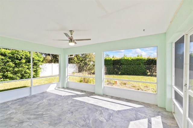 unfurnished sunroom featuring ceiling fan