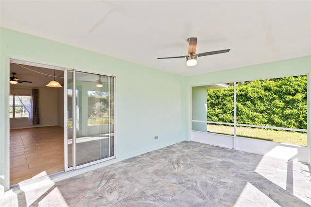 unfurnished sunroom featuring ceiling fan