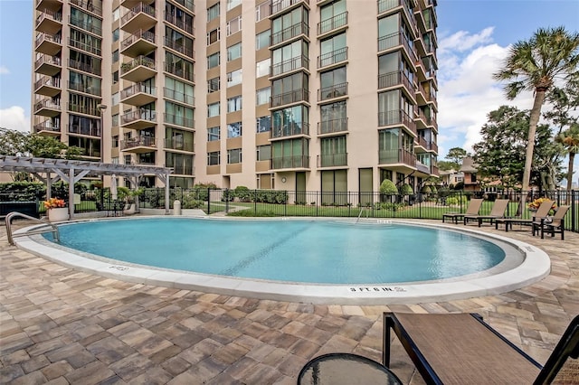 view of pool with fence and a pergola