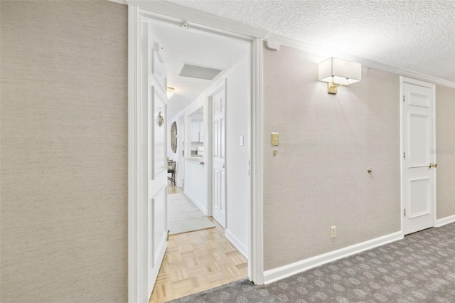 corridor featuring baseboards and a textured ceiling