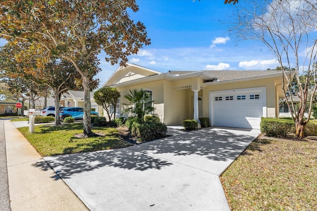 view of front of property featuring stucco siding, a front lawn, concrete driveway, and a garage