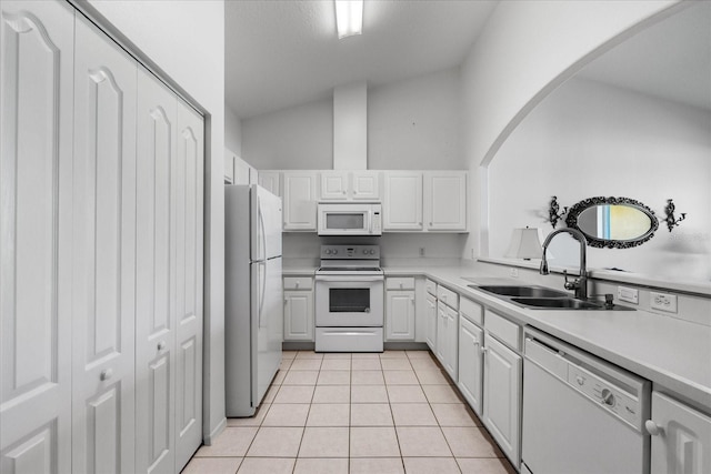 kitchen featuring white appliances, light tile patterned floors, a sink, light countertops, and white cabinets