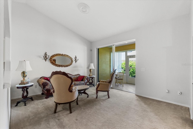 living area featuring lofted ceiling, light colored carpet, and baseboards