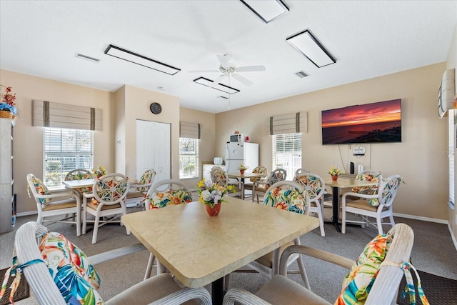 dining space with baseboards, visible vents, and ceiling fan