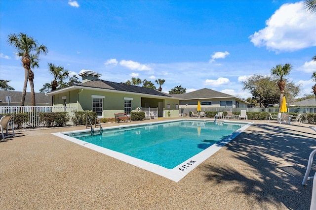 pool with a patio and fence