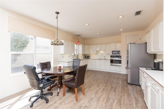 dining space featuring recessed lighting, visible vents, and light wood finished floors