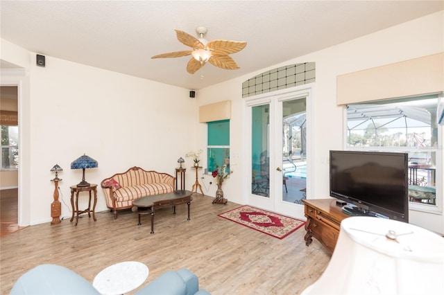 living room with french doors, a textured ceiling, a ceiling fan, and wood finished floors