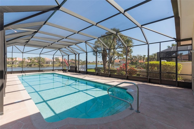 outdoor pool featuring a patio area, glass enclosure, and a water view