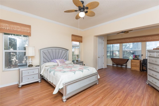 bedroom with crown molding, light wood-style floors, baseboards, and a textured ceiling