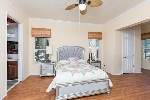 bedroom featuring a ceiling fan, baseboards, ornamental molding, light wood-style floors, and a textured ceiling