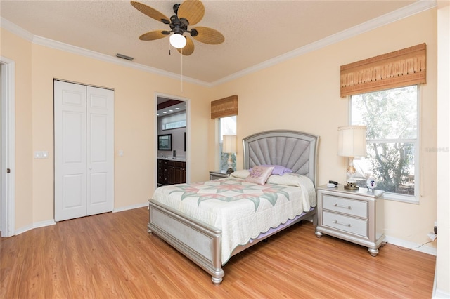 bedroom with baseboards, visible vents, light wood finished floors, and ornamental molding