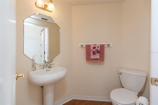 bathroom with visible vents, baseboards, toilet, and wood finished floors