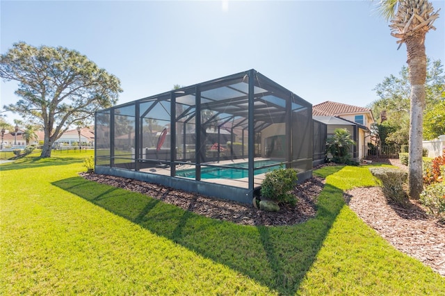 outdoor pool with glass enclosure and a yard