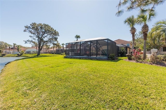 view of yard with a lanai and a water view