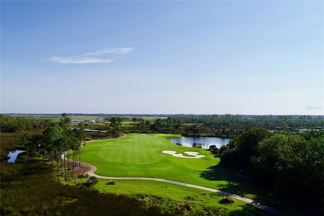 drone / aerial view featuring golf course view and a water view