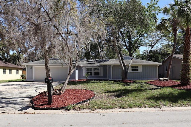 ranch-style home featuring concrete driveway, an attached garage, and a front lawn