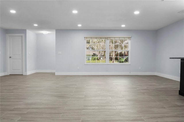 unfurnished living room featuring recessed lighting, baseboards, and light wood-style floors